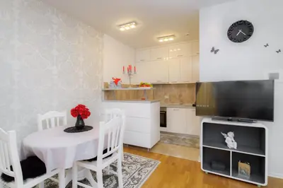 a kitchen and dining room with a table and a tv at HarMony apartment in Budva