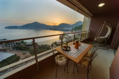 a balcony with a table and chairs and a view of the ocean at HarMony apartment in Budva