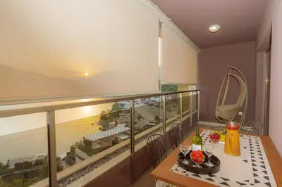 a balcony with a table and a view of the ocean at HarMony apartment in Budva