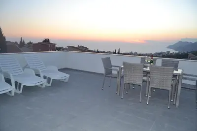 a patio with chairs and a table on a roof at Kevin-Talisa Villa in Bar