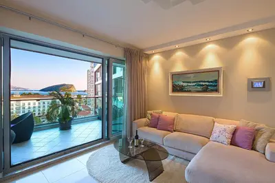 a living room with a couch and a large window at Premier LUX apartment in Budva