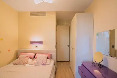a bedroom with a bed with pink pillows at Premier LUX apartment in Budva