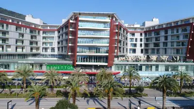 a large red building with palm trees in front of it at Premier LUX apartment in Budva