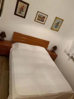 a bedroom with a white bed with three pictures on the wall at Sea forever in Petrovac na Moru