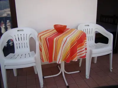 a table with two chairs and a bowl on top of it at Apartments Svorcan in Budva