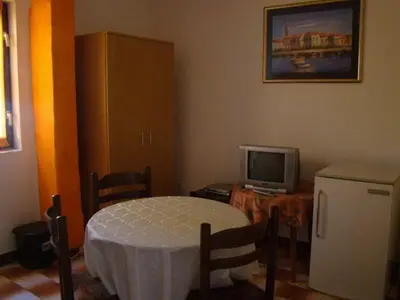 a living room with a table and a tv and a small refrigerator at Apartments Svorcan in Budva
