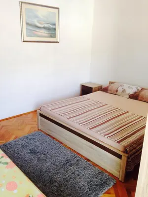 a bed in a room with a blue rug at Apartments Svorcan in Budva