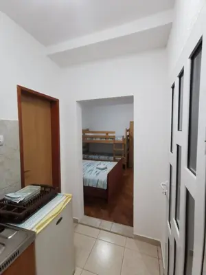 a room with a kitchen and a bedroom with a bed at Bar-Apartman 2 in Bar