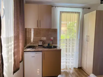 a small kitchen with a sink and a window at Apart dom Janković in Sutomore
