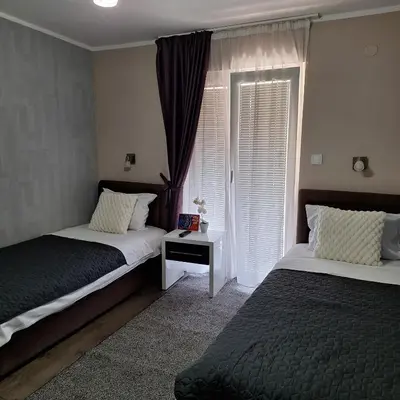 a bedroom with two beds and a window at Family Apartment in Cetinje