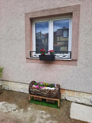 a window with a bench with flowers in it at Family Apartment in Cetinje