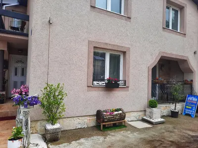 a house with a bench in front of a window at Family Apartment in Cetinje
