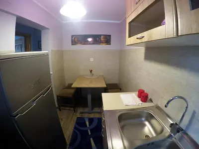 a small kitchen with a sink and a table at Family Apartment in Cetinje