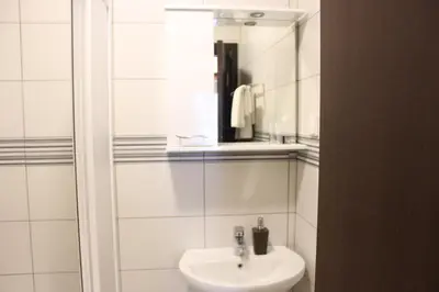 a white bathroom with a sink and a mirror at Apartments Balabusic in Budva