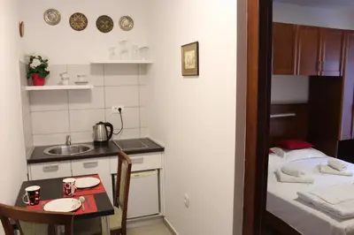 a small kitchen with a small table and a bed at Apartments Balabusic in Budva