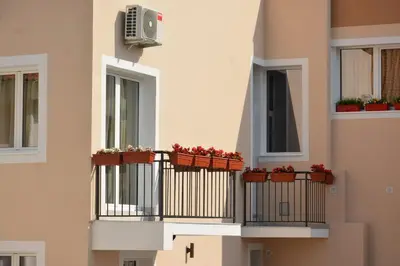 a building with potted plants on the balconies at Apartments Balabusic in Budva