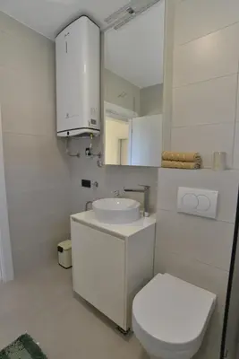 a bathroom with a sink and a toilet and a mirror at Villa Jovanovic in Tivat