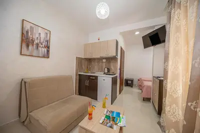 a small living room with a couch and a kitchen at Kristal Apartmani in Čanj