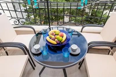 a bowl of fruit on a glass table on a balcony at Kristal Apartmani in Čanj