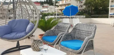 two chairs and a table with an umbrella on a patio at Kristal Apartmani in Čanj