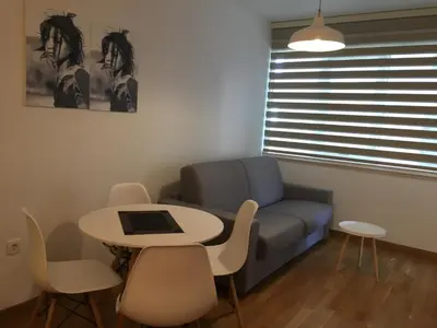 a living room with a couch and a table and chairs at Lungomare Lux Apartments in Budva