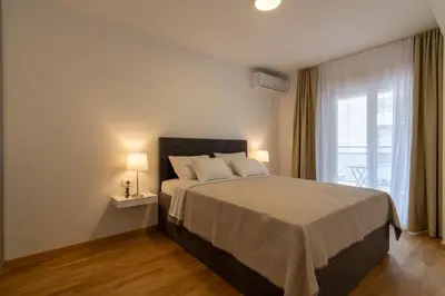 a bedroom with a large bed and a window at Lungomare Lux Apartments in Budva