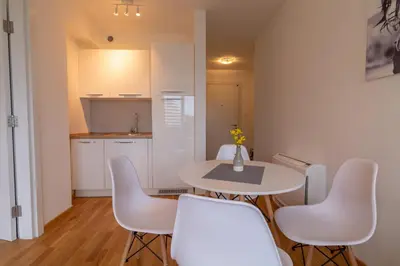 a kitchen with a table and white chairs in a room at Lungomare Lux Apartments in Budva