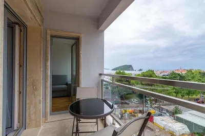 a balcony with a table and chairs and a view at Lungomare Lux Apartments in Budva