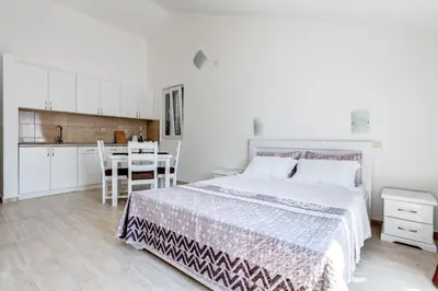 a bedroom with a bed and a table and a kitchen at Villa SAN Apartments in Tivat