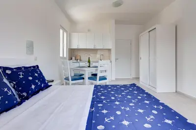 a bedroom with a bed and a kitchen with a table at Villa SAN Apartments in Tivat
