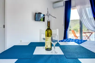 a bottle of wine sitting on a table with a glass at Villa SAN Apartments in Tivat