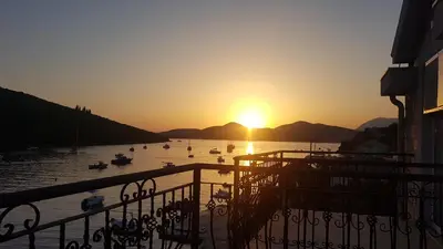 a sunset over a body of water with boats in it at Villa SAN Apartments in Tivat