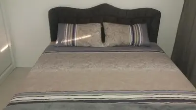 a bed with a brown comforter and two pillows at Holiday Home Duka's in Bar