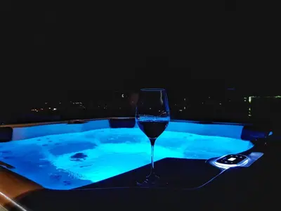 a wine glass sitting on a table next to a hot tub at Villa Preciosa in Kotor