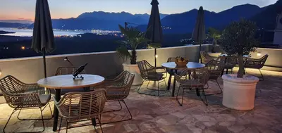 a patio with tables and chairs on a balcony at Villa Preciosa in Kotor