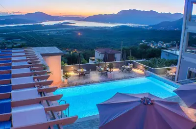 a pool on top of a building with tables and umbrellas at Villa Preciosa in Kotor