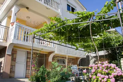 a house with a balcony and flowers in front of it at Apartments Lux seaview in Bar