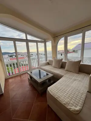 a living room with a couch and some windows at Apartments Lux seaview in Bar