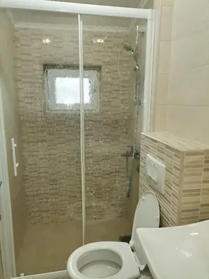 a bathroom with a toilet and a glass shower at Apartments Lux seaview in Bar