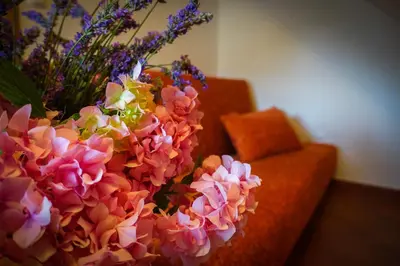 a vase filled with flowers next to a couch at Markov konak in Cetinje
