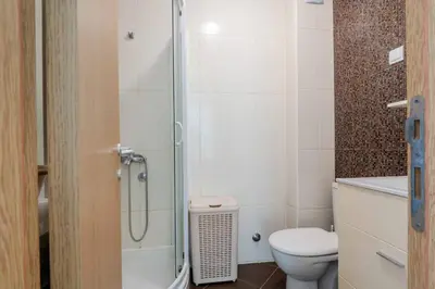 a bathroom with a shower with a toilet and a sink at 1bd Modern Apt in Dobra Voda with Roof Access 