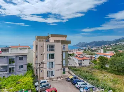 a city with cars parked in a parking lot at 1bd Modern Apt in Dobra Voda with Roof Access 