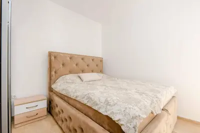 a bed in a bedroom with a white wall at 1bd Modern Apt in Dobra Voda with Roof Access 