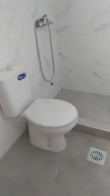 a white toilet in a bathroom with a shower at Apartmani Scepanovic in Sutomore