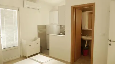 a white kitchen with a sink and a refrigerator at Apartmani Scepanovic in Sutomore