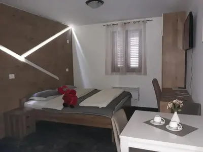 a bedroom with a bed with a teddy bear on it at Tilia in Cetinje