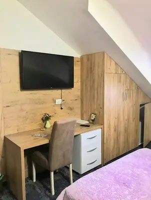 a bedroom with a desk with a television on a wall at Tilia in Cetinje