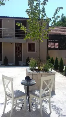 two chairs and a table and a tree in a yard at Tilia in Cetinje
