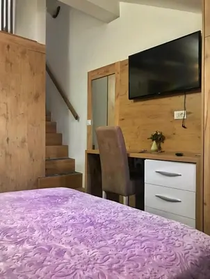 a bedroom with a bed and a desk with a tv at Tilia in Cetinje