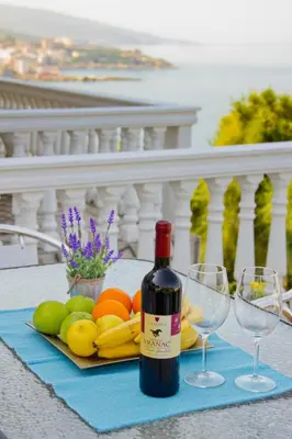 a bottle of wine sitting on a table with glasses at Apartments Dora in Dobra Voda